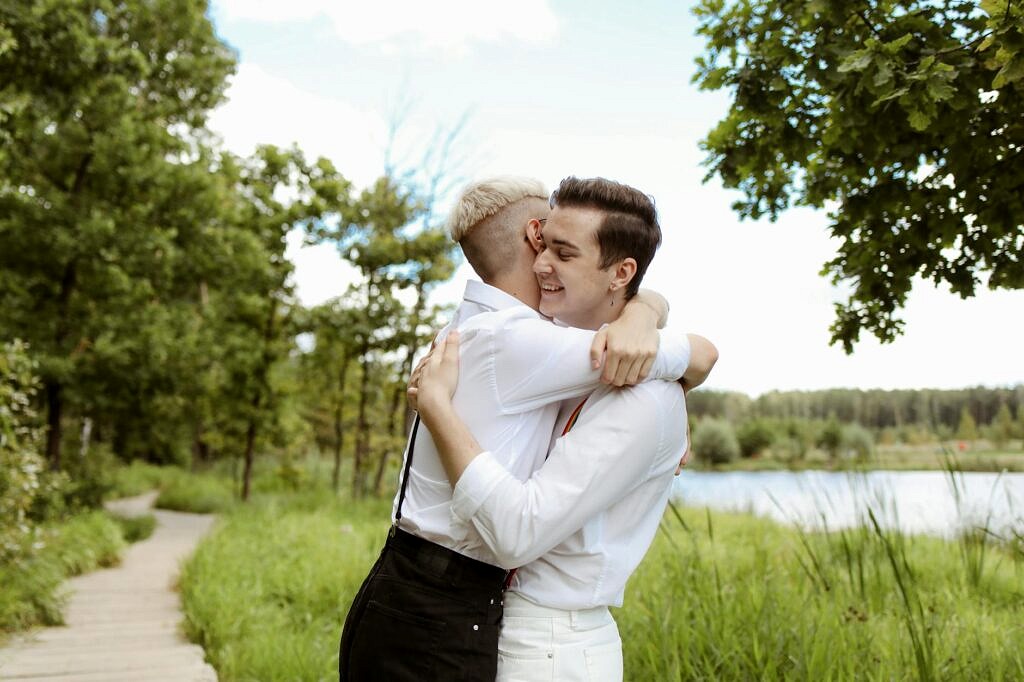 men embracing standing on path in park